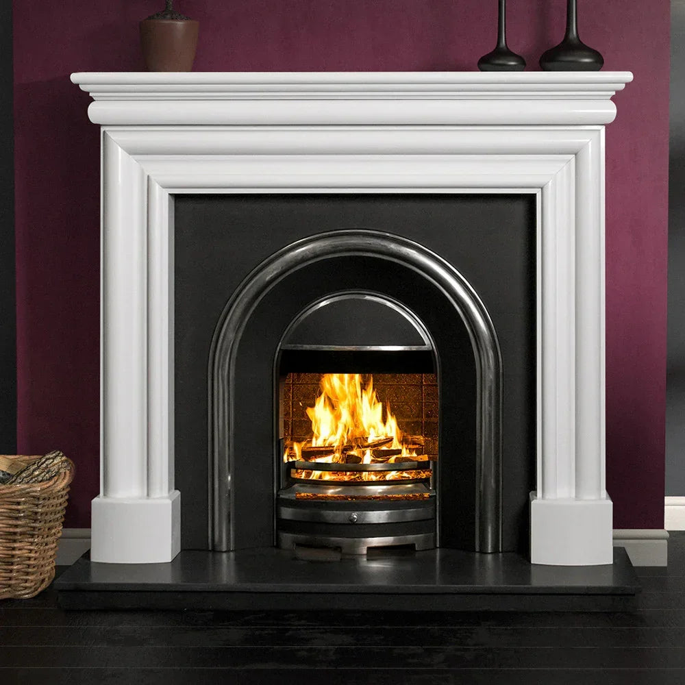 Polished polar white fireplace surround with arched cast iron insert and burning fire