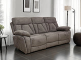 A three-seat gray reclining sofa with plush padded cushions, shown in a modern living room setting with dark tiled flooring, white curtains, and a floor lamp.