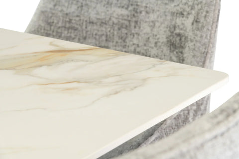 Close up of marble dining table top with grey fabric chair in background