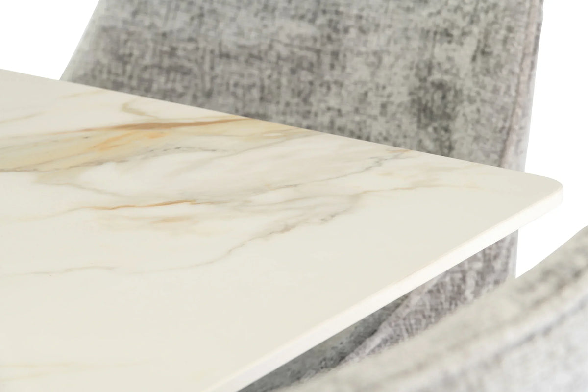 Close up of marble dining table top with grey fabric chair in background
