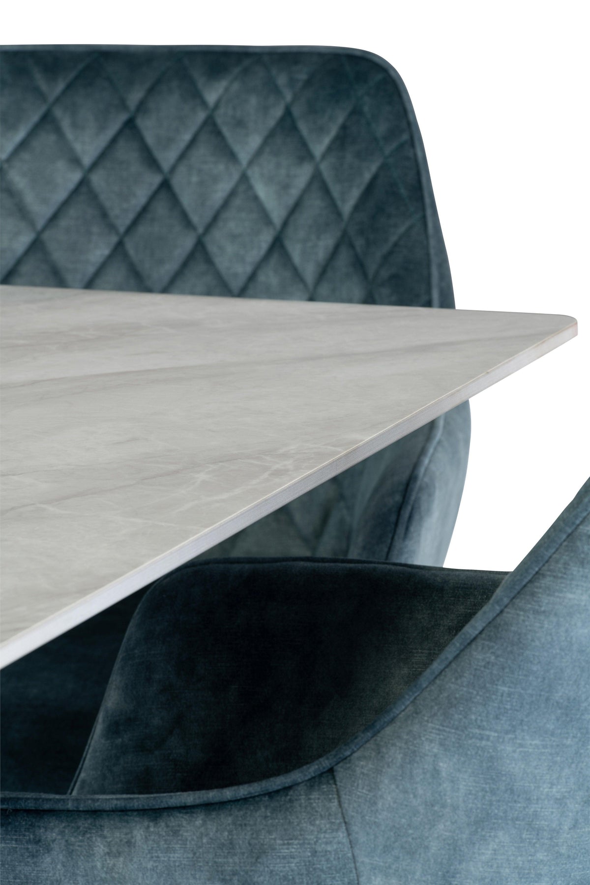 Close up of marble dining table with blue velvet quilted dining chair