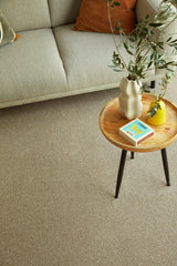 Beige carpet in living room styled with wooden table, vase, and greenery — cozy setting