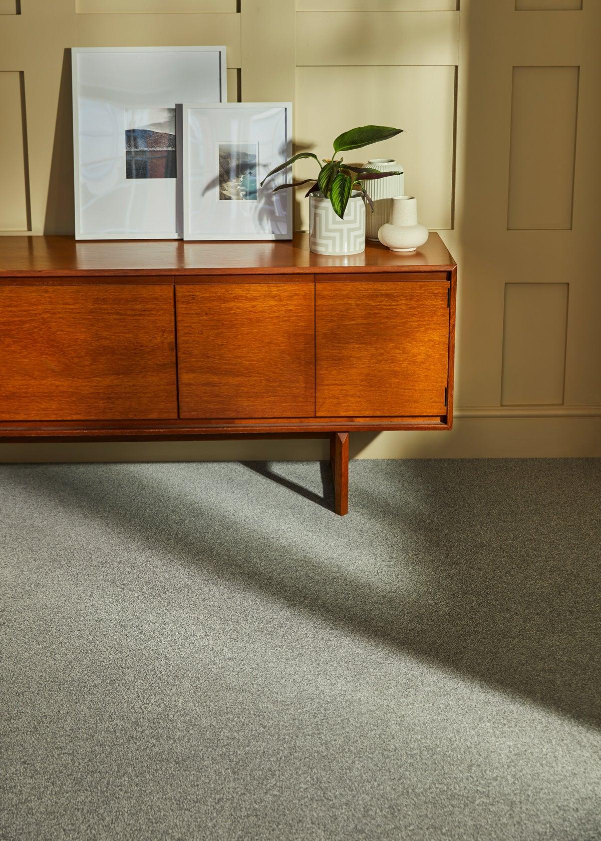 Kingston Silverbirch carpet in living room with wooden sideboard and plant decor