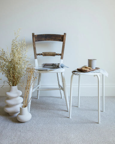 apollo plus shortbread carpet in a room with a wooden chair, white side table, and ceramic vases