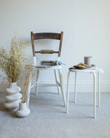apollo plus shortbread carpet in a room with a wooden chair, white side table, and ceramic vases
