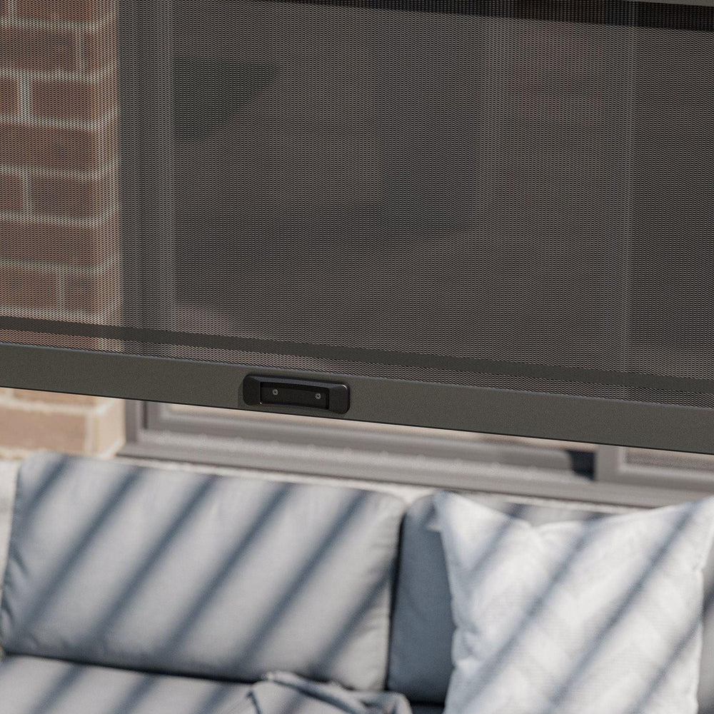 Mesh patio curtain with control panel over outdoor sofa and cushions