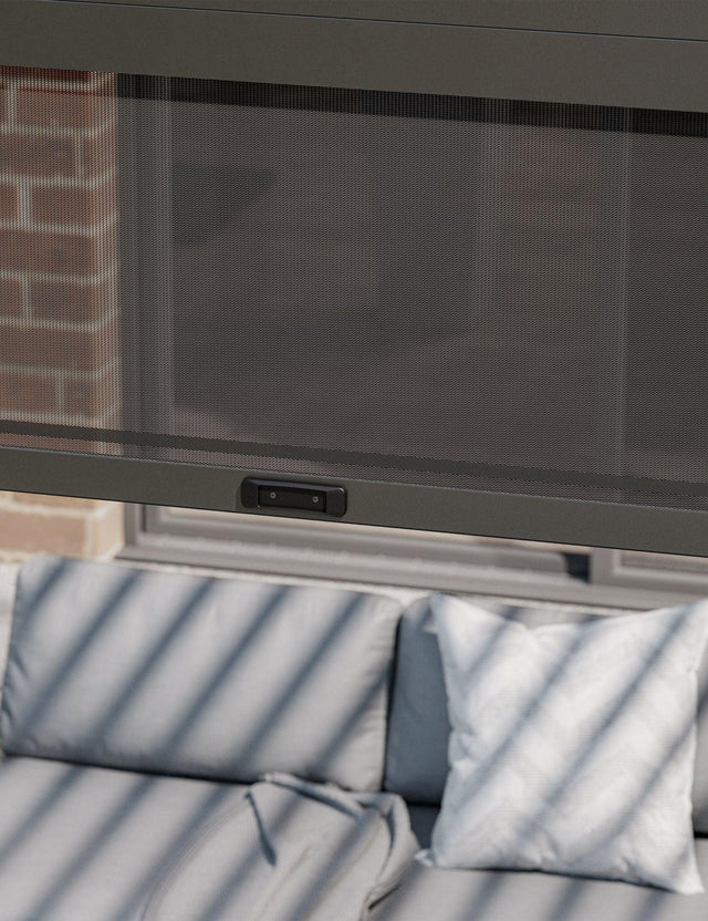 Mesh patio curtain with control panel over outdoor sofa and cushions
