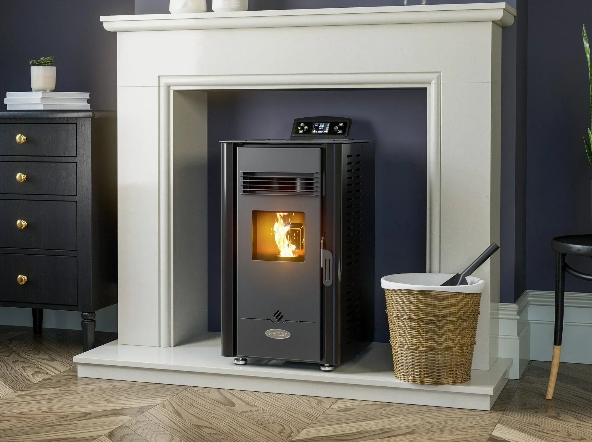 Black freestanding pellet stove with digital display set in cream fireplace, burning flame visible