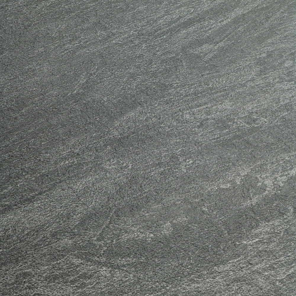 A close-up of a dark gray stone or concrete-like textured surface with subtle lighter gray veining and grain.