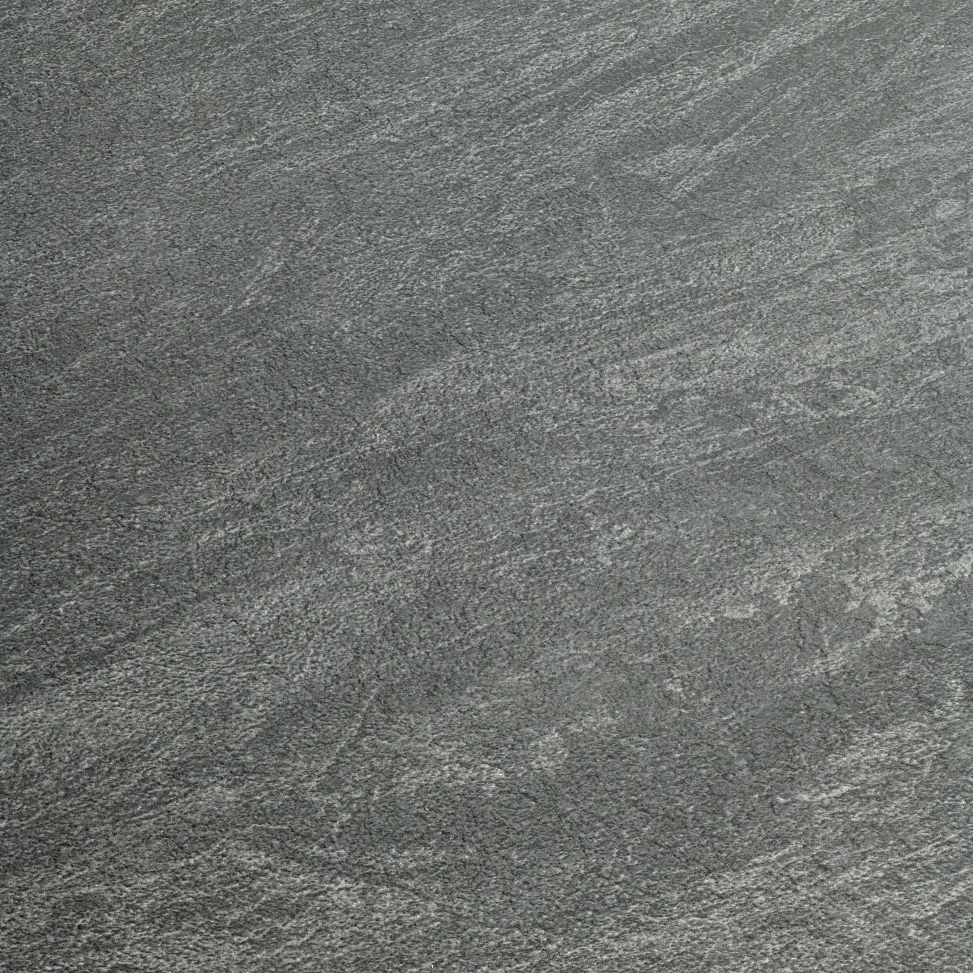 A close-up of a dark gray stone or concrete-like textured surface with subtle lighter gray veining and grain.