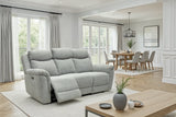 A light gray upholstered reclining loveseat sofa shown in a bright, modern living room with a coffee table, rug, and large windows. The front cushion is extended, showing the reclining function.