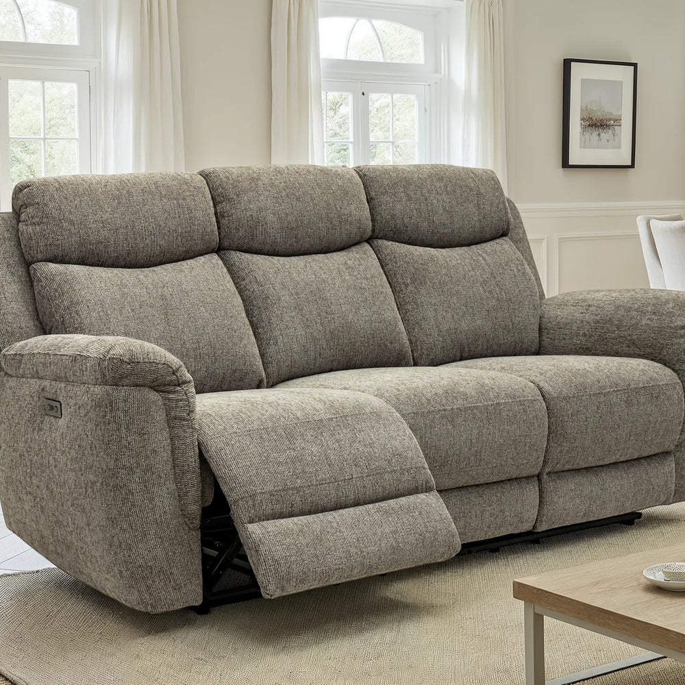A three-seat power reclining loveseat sofa upholstered in textured gray fabric, shown in a bright, modern living room with one seat reclined.