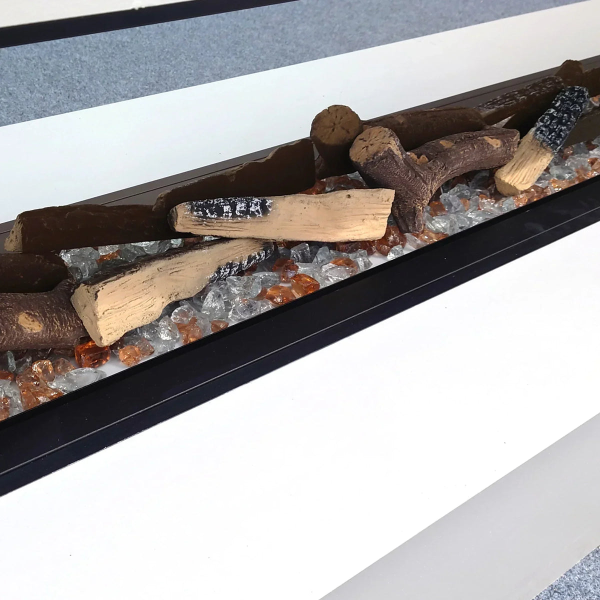 Modern fuel bed with ceramic logs and glass crystals in linear black fire grate