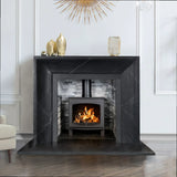Black marble fireplace surround with lit wood burning stove and modern decor accents