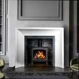 Limestone fireplace surround with modern wood burning stove and grey tiled interior