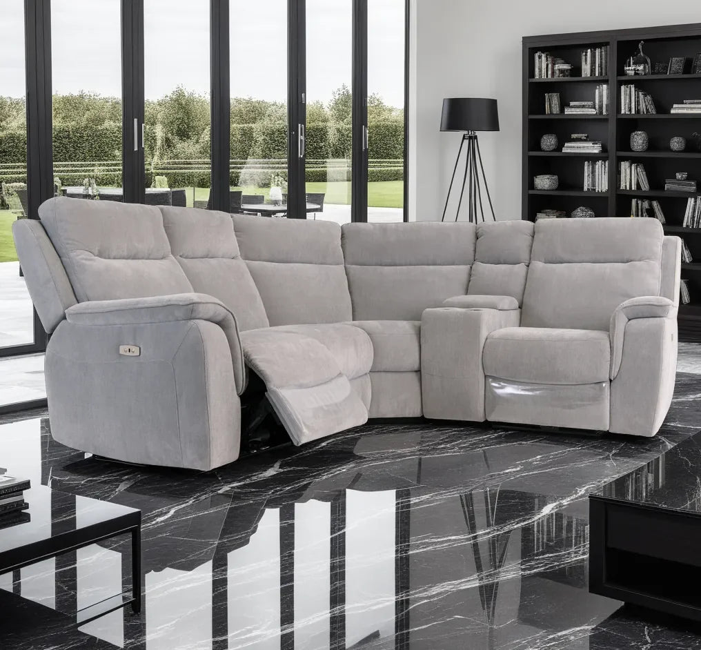 Gray sectional sofa in a modern living room with large windows and bookshelf.