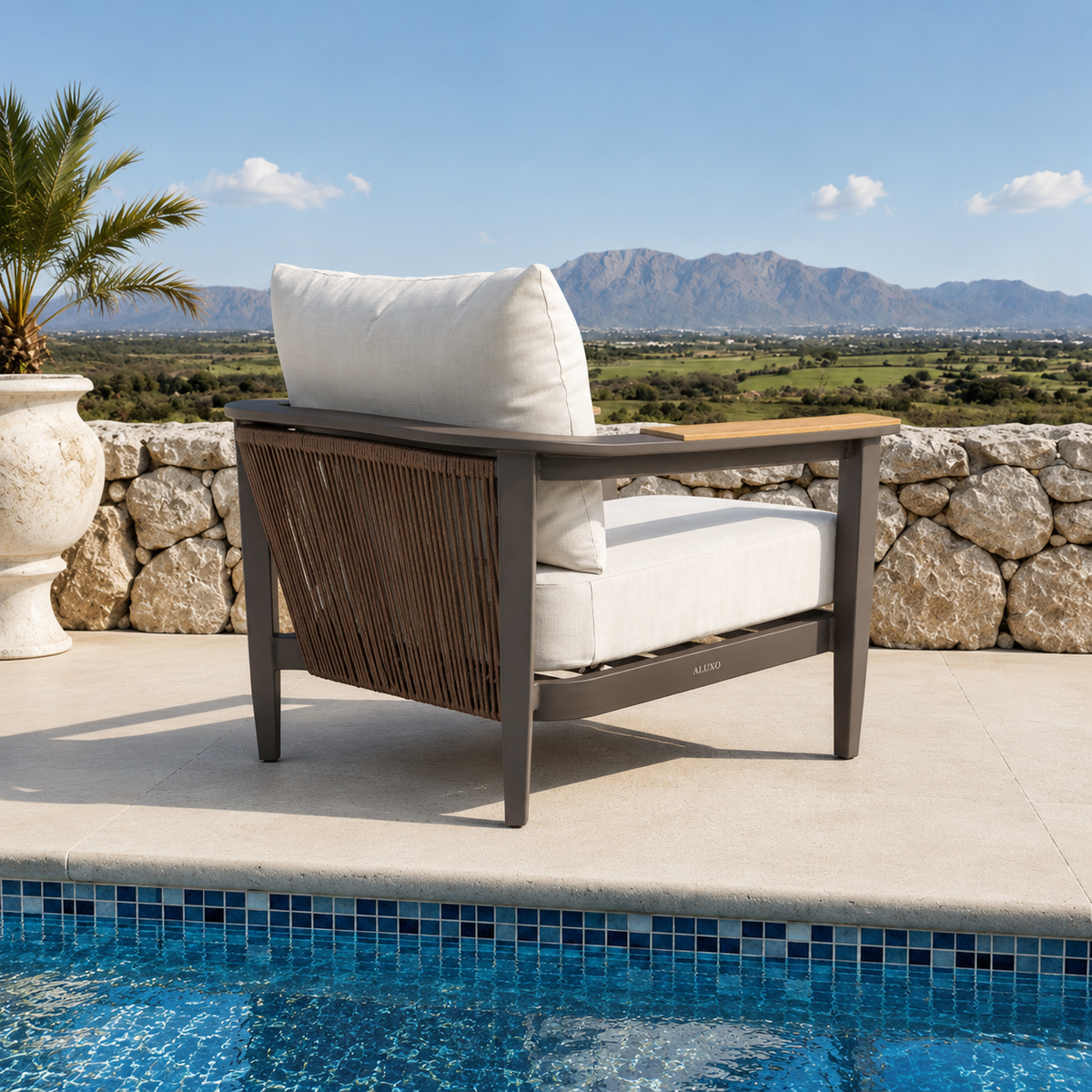 Cream fabric cushions on dark brown metal chair frame with woven rope sides near pool
