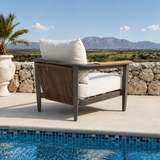 Cream fabric cushions on dark brown metal chair frame with woven rope sides near pool