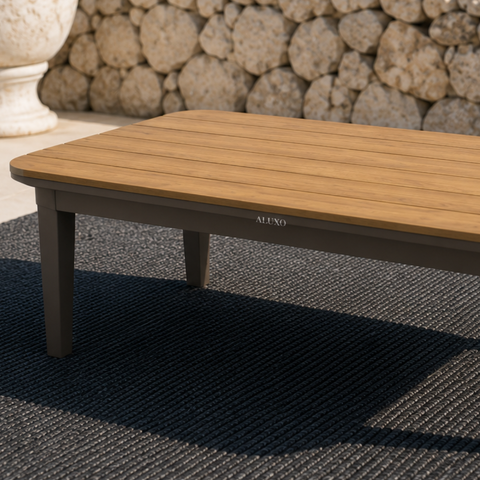 Light brown wooden slatted tabletop with dark grey sturdy legs on textured black rug.