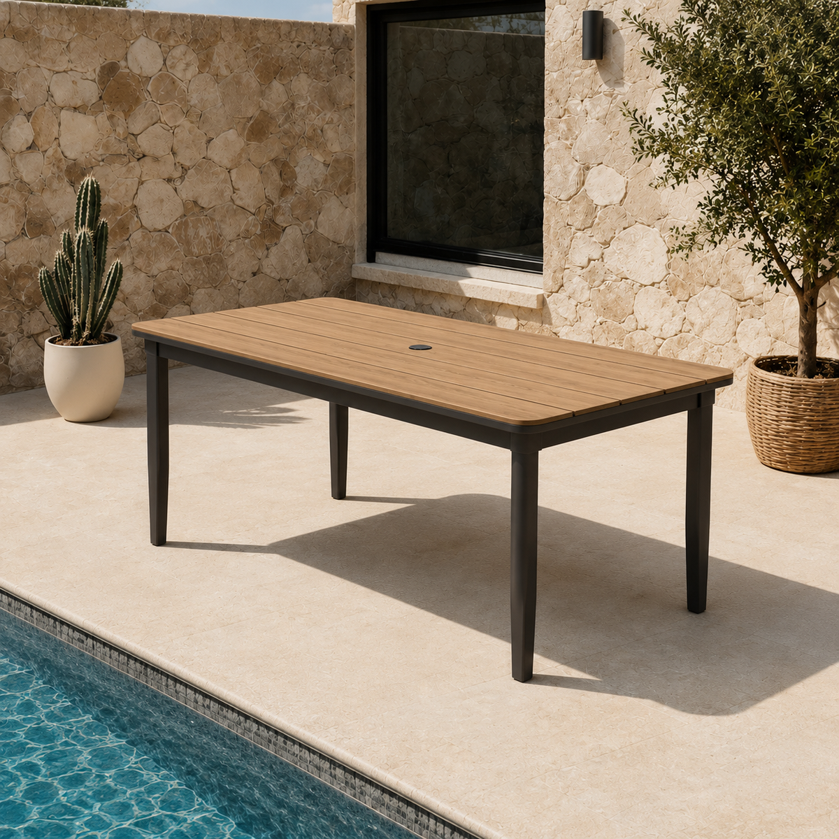 Light brown wooden tabletop with black metal legs beside pool and stone wall background