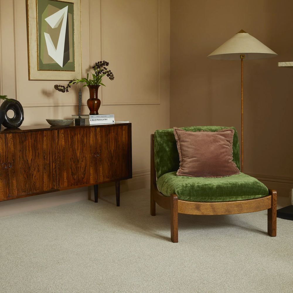Saxony Venetian Marble carpet in lounge with green velvet chair, sideboard, and marble fireplace