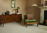 Saxony Venetian Marble carpet in lounge with green velvet chair, sideboard, and marble fireplace