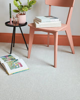 Light saxony carpet in modern room with blush chair, small black side table, and decor accents
