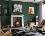 Modern living room with wood burning stove, geometric rug, armchairs, and green walls