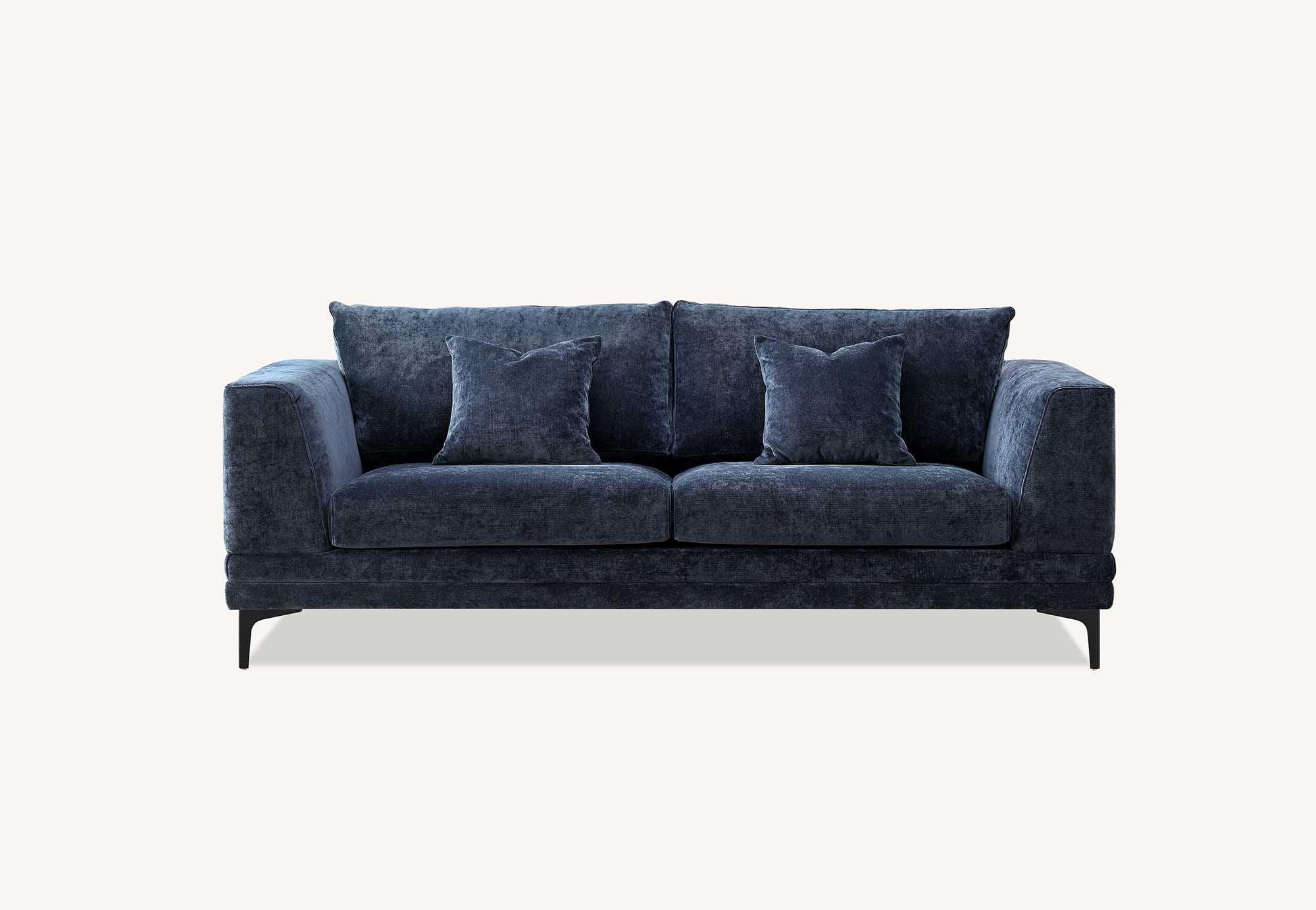Blue velvet sofa with two matching scatter cushions and slim black legs, front view