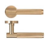 Brushed brass door handle set with knurled textured grip and round backplate