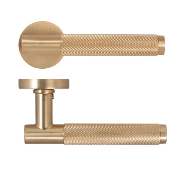 Brushed brass door handle set with knurled textured grip and round backplate