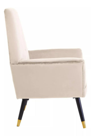 Side view of stone velvet accent chair with slim black and gold legs