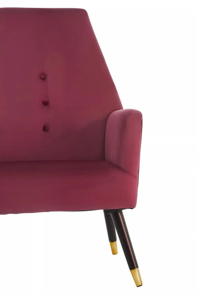 Wine velvet accent chair with button detail and gold-tipped wooden legs, partial side view