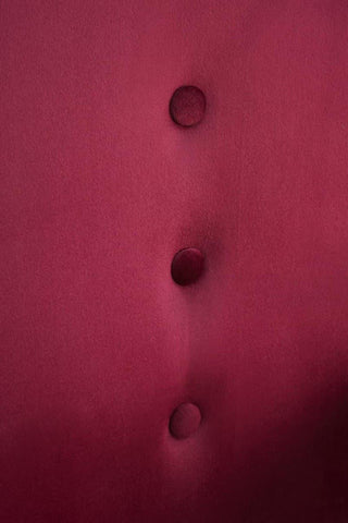 Wine velvet chair close-up showing button detailing on upholstery