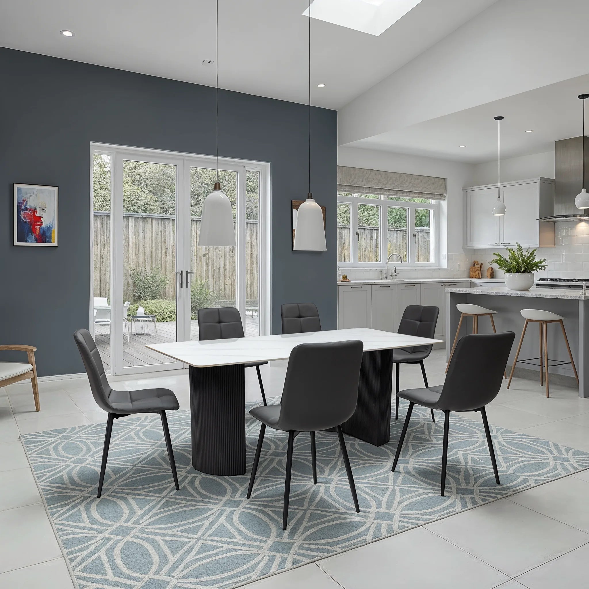 Modern kitchen and dining area with a white table and gray chairs.