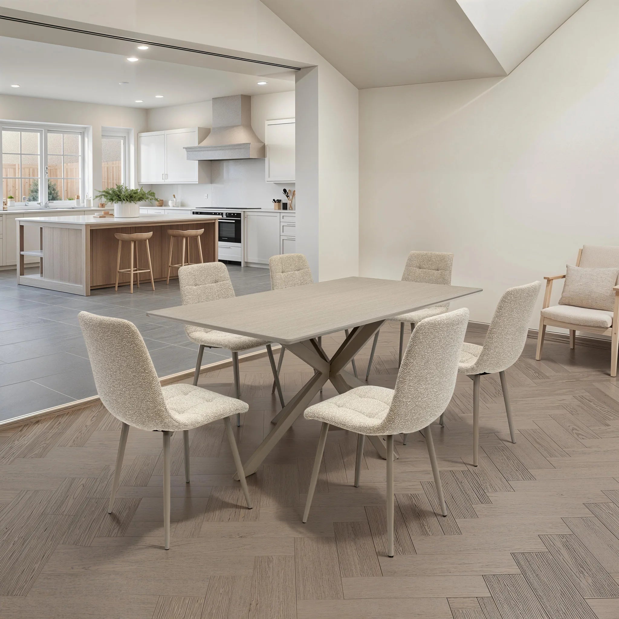 A modern dining room scene featuring a rectangular light gray stone dining table surrounded by six upholstered dining chairs in a textured cream fabric with slim metallic legs. The room has light gray herringbone wood flooring, off-white walls, and an open doorway leading to a contemporary kitchen in the background.