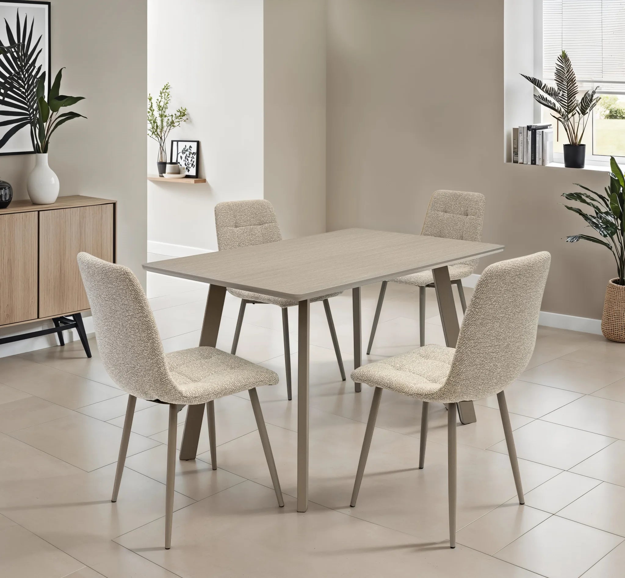 A modern dining set featuring a rectangular light gray table with tapered metal legs and four upholstered dining chairs in a textured cream bouclé fabric, set in a bright, contemporary dining room.