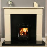 Stone fireplace with black hearth, wood burning stove and mantel decor in modern living room