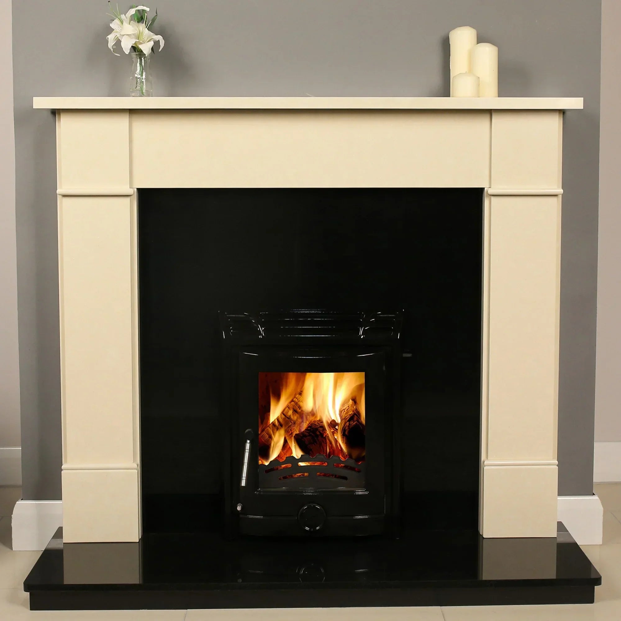 Stone fireplace with black hearth, wood burning stove and mantel decor in modern living room
