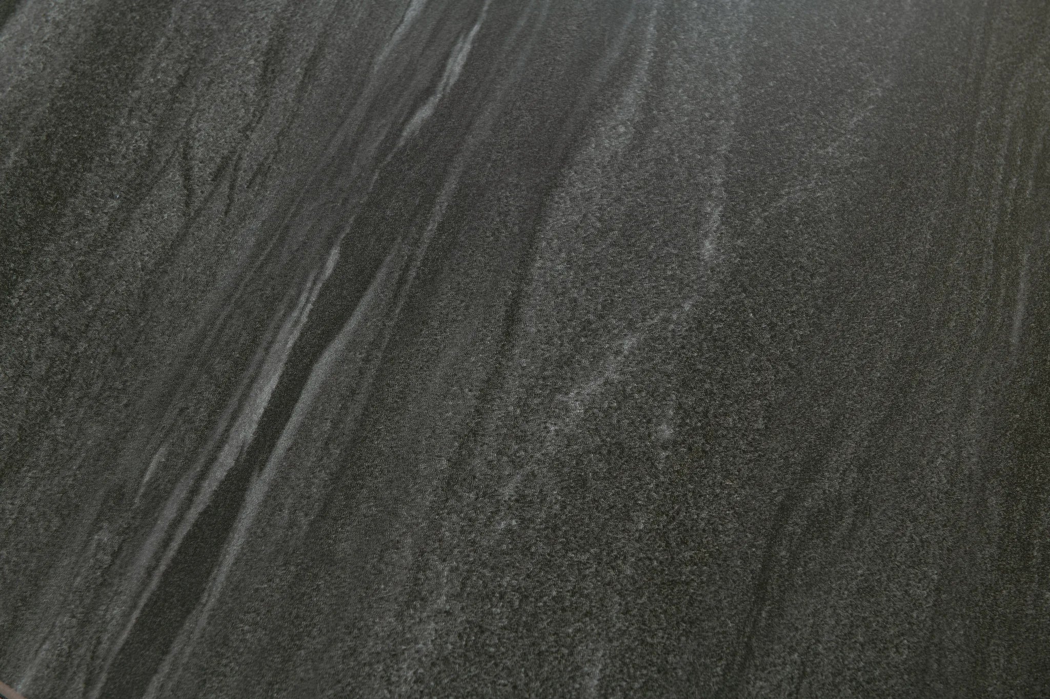 Dark gray textured surface with a mottled stone or concrete-like pattern and subtle lighter gray veining.