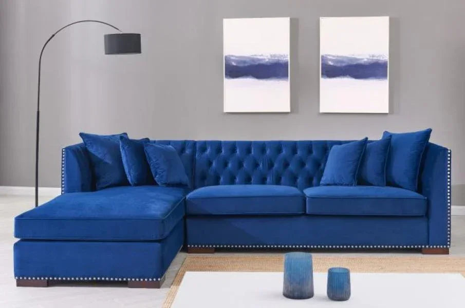 Blue velvet corner sofa with button tufting and studded trim in modern living room