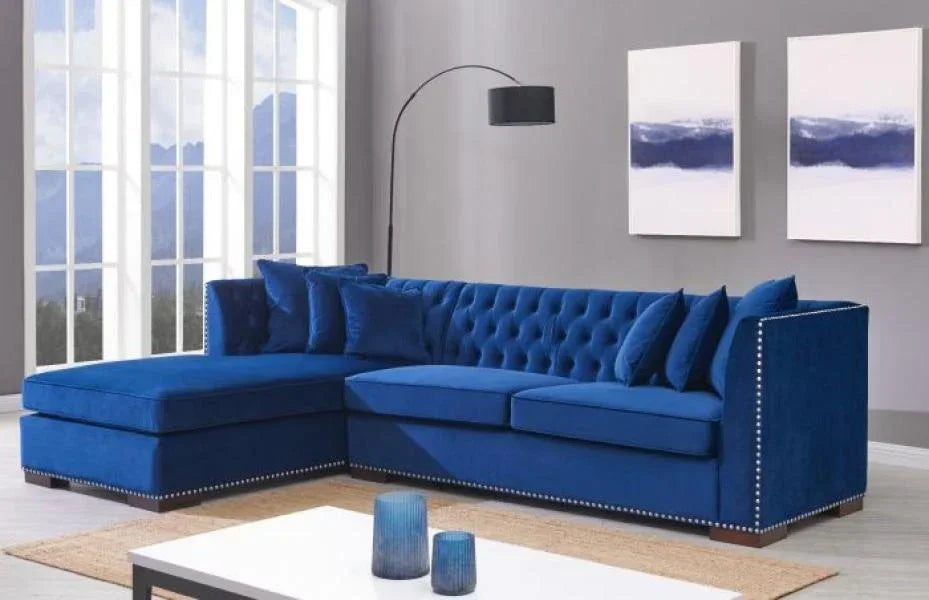 Blue velvet corner sofa with button tufting and studded trim in modern living room