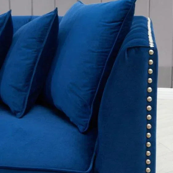 Blue velvet sofa with studded armrest and matching scatter cushions
