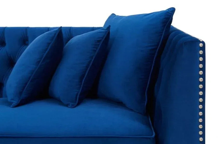 Blue velvet sofa with studded armrest and three matching scatter cushions