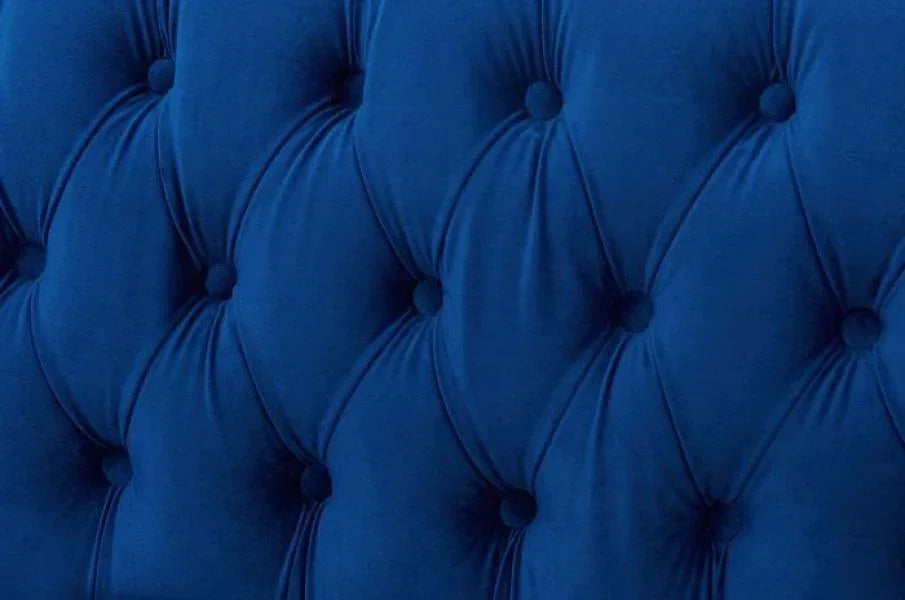 Close-up of blue velvet tufted sofa upholstery with button detail