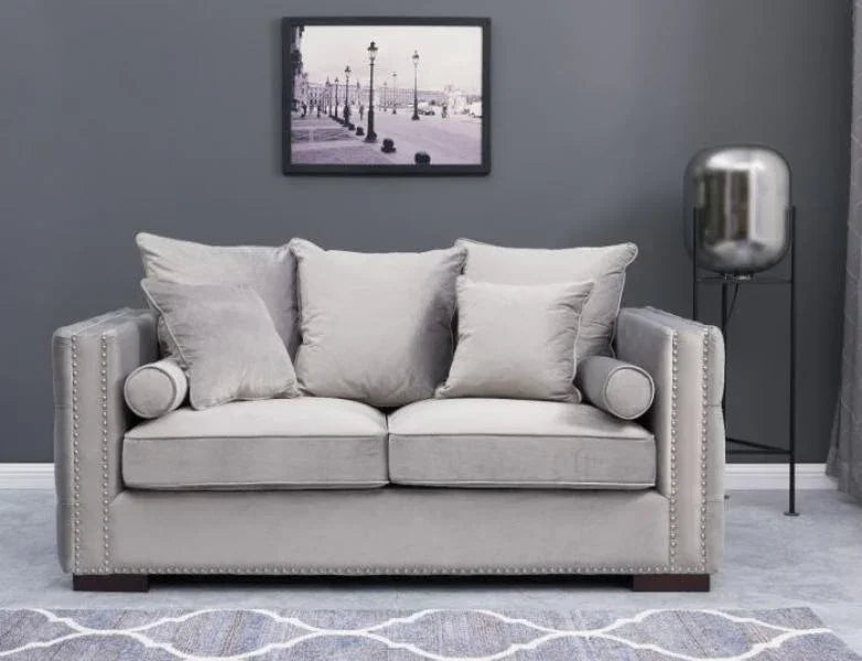 Grey fabric sofa with studded arms and scatter cushions in modern living room