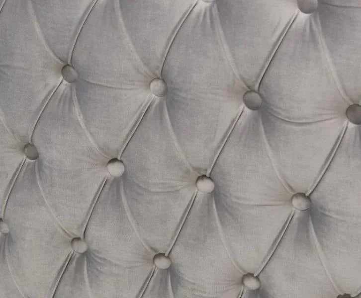Grey velvet button tufted sofa upholstery close-up