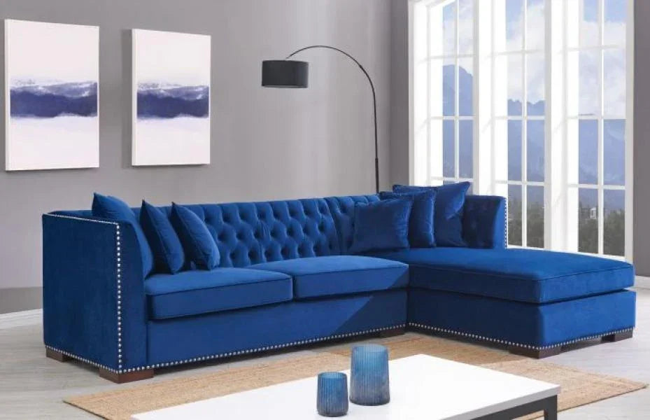 Blue velvet corner sofa with tufted back and silver stud trim in modern living room