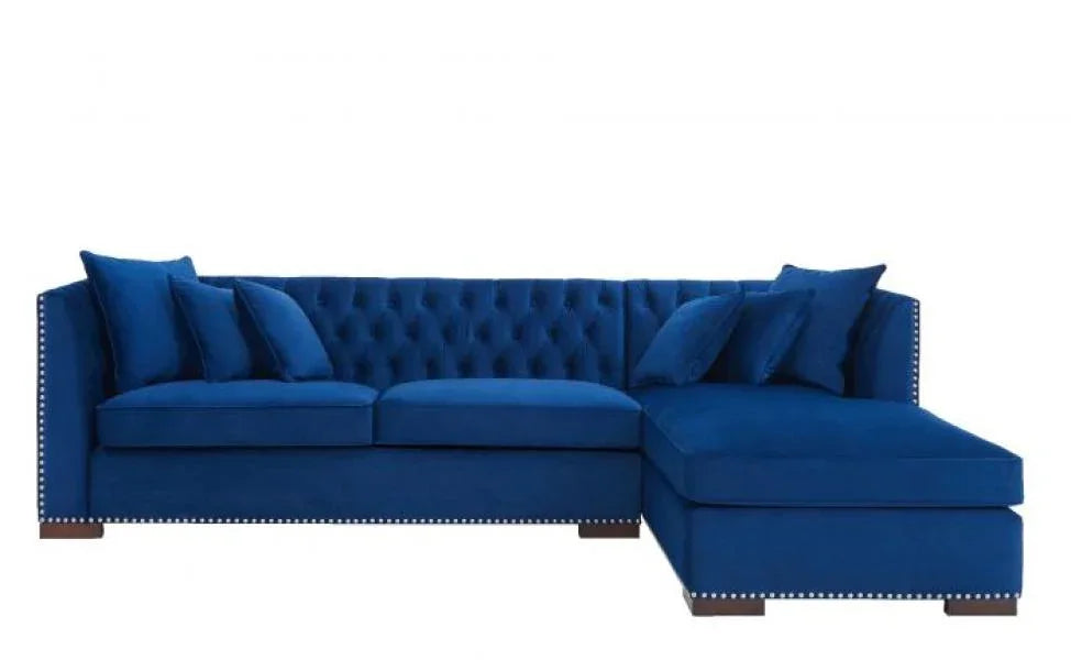 Blue velvet corner sofa with tufted back, stud detailing, and chaise lounge section