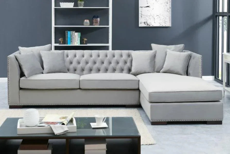 Light grey corner sofa with tufted back and scatter cushions in modern living room